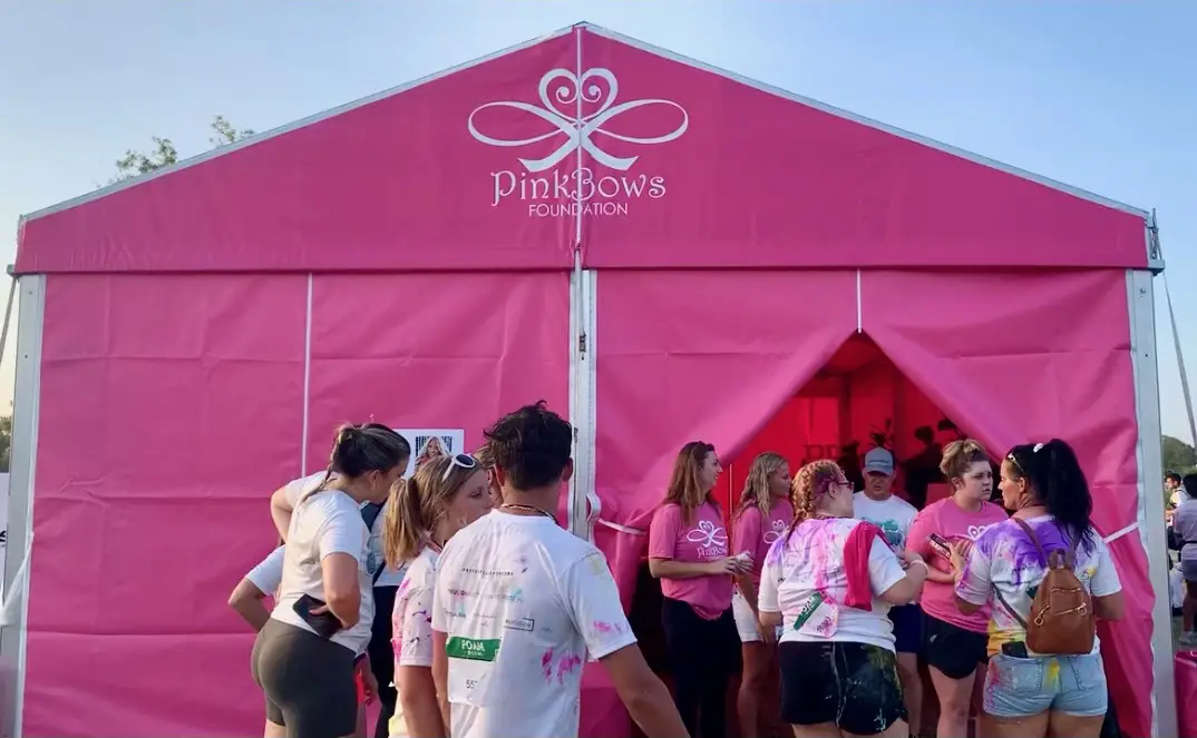 Concertgoers stopping by the Pink Bows Foundation tent